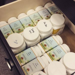 A drawer filled with jars of various ingredients.